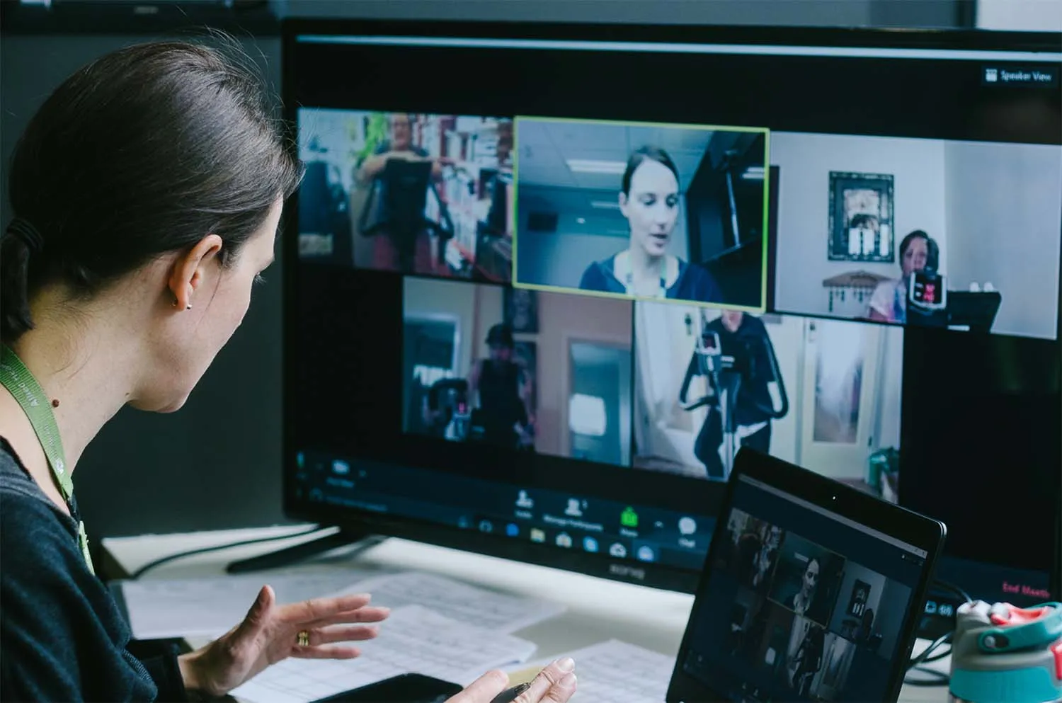 A clinician runs a virtual pulmonary rehabilitation session, monitoring participants on a multi-screen setup.